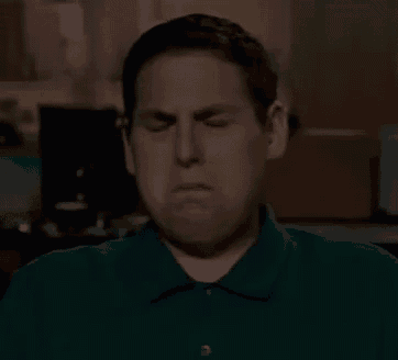 a man in a green shirt is making a sad face .
