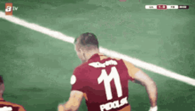 a soccer player with the number 11 on his jersey is running on the field