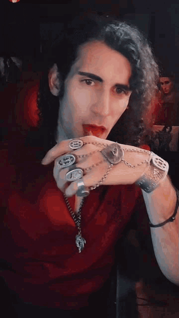 a man with a lot of rings on his fingers including one that has the letter r on it