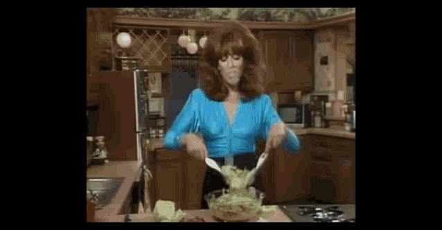 a woman is making a salad in a kitchen
