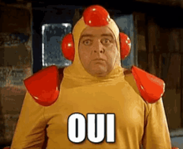 a man in a chicken costume is wearing headphones and a yellow shirt with the word oui on it .