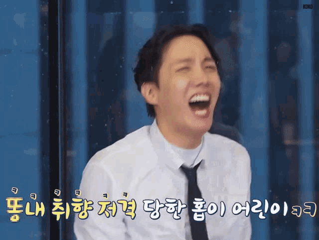 a man wearing a white shirt and black tie is laughing in a foreign language