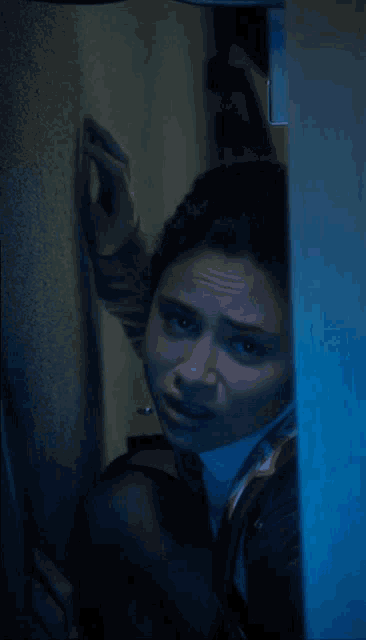 a woman with a scarf around her neck is looking through a window
