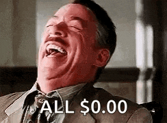 a man in a suit and tie is laughing with his eyes closed and his mouth open .