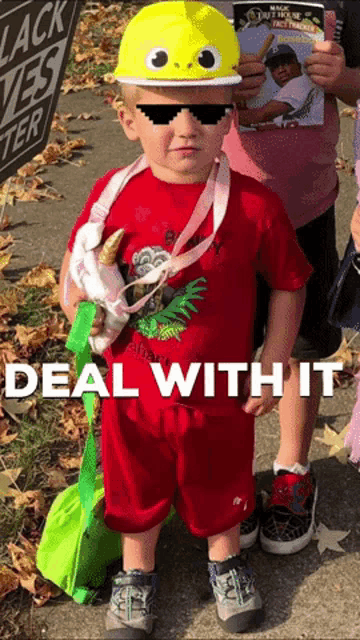 a little boy wearing a yellow hat and sunglasses with the words deal with it written below him