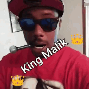 a man wearing sunglasses and a red shirt with the words king malik written on it