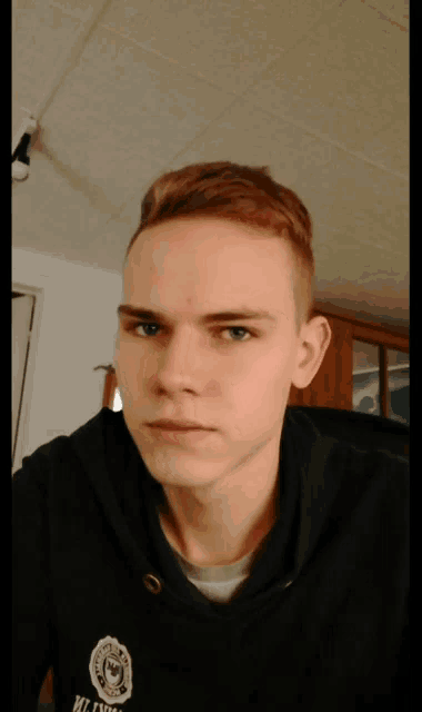 a young man is wearing a black sweatshirt with a badge on the front that says milwaukee police