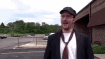 a man wearing a suit and tie is standing in a parking lot