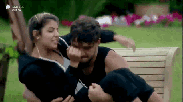 a man is carrying a woman in his arms on a bench .