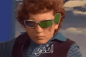 a young boy wearing sunglasses with arabic writing on them