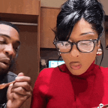a woman wearing glasses and a red sweater is being served by a man