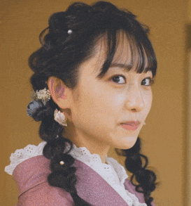 a close up of a woman 's face with pigtails and earrings