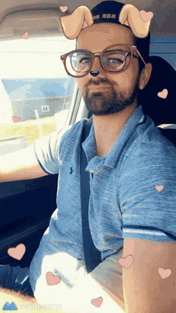 a man in a car wearing glasses and a hat with dog ears