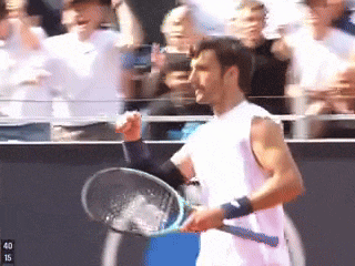 a man holding a tennis racquet in front of a crowd with the number 40 on the bottom