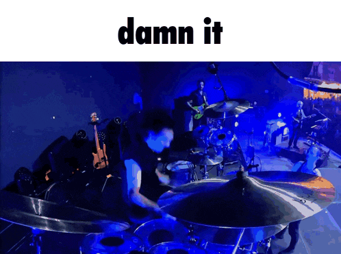 a man playing drums on a stage with the words damn it below him