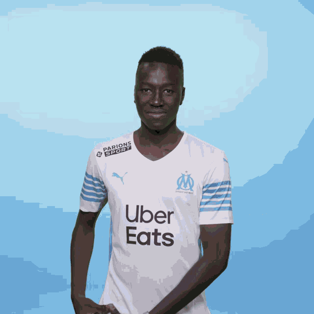 a man wearing a white uber eats shirt