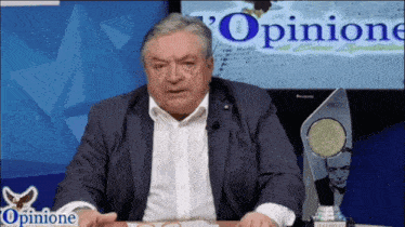 a man in a suit stands in front of a sign that says opinion