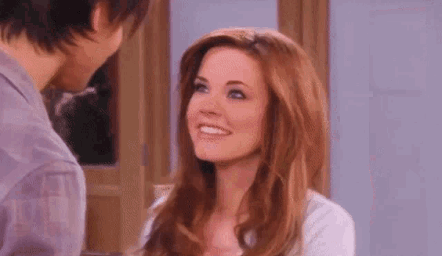 a man and a woman are standing next to each other and smiling .