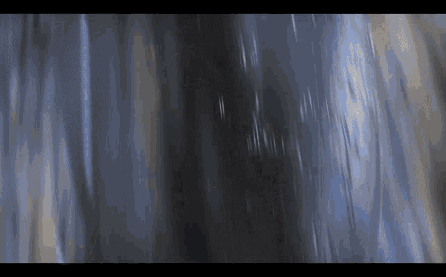 a blurry picture of a waterfall with a blue background