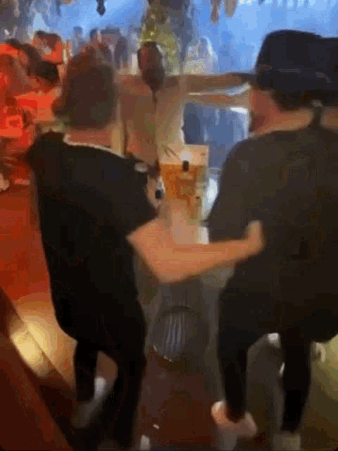 a group of people are sitting at a table in a restaurant and dancing .