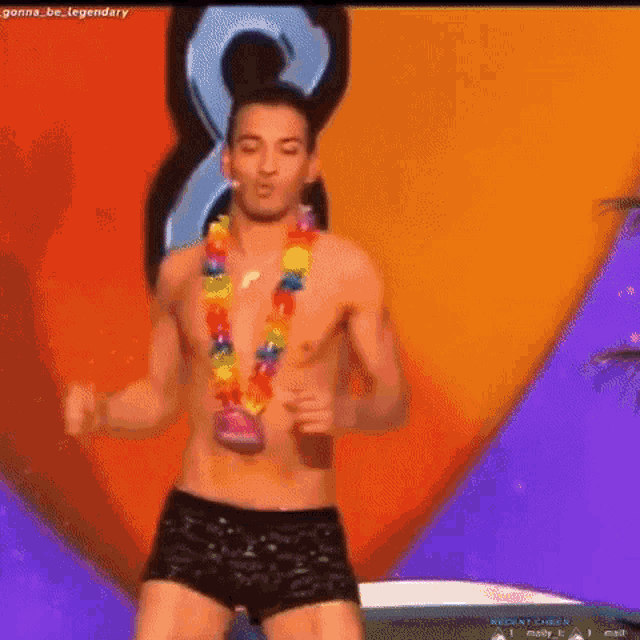 a shirtless man wearing a lei is dancing on a stage