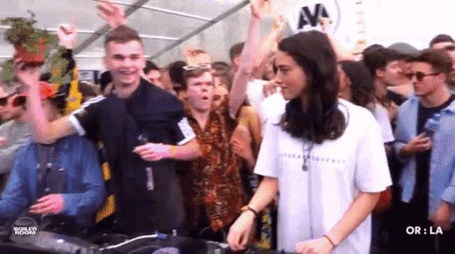 a woman in a white shirt with the word tommy on it stands in front of a crowd