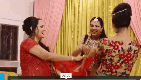 three women are dancing together in a room with a yellow curtain behind them and the time is 2:50