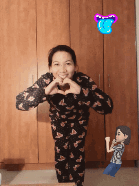 a woman making a heart shape with her hands in front of a wooden cabinet