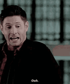 a man in a black jacket is making a funny face and saying `` ooh . ''