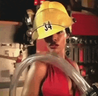 a woman wearing a yellow fireman 's hat is holding a hose .