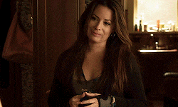 a woman with long hair is holding a cell phone