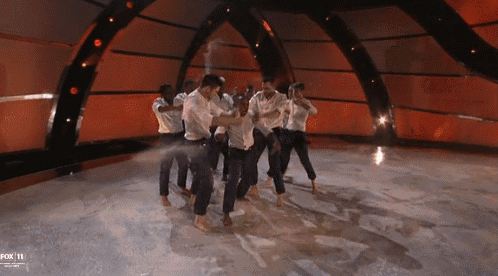 a group of men are dancing on a stage with fox 11 written on the bottom of the screen