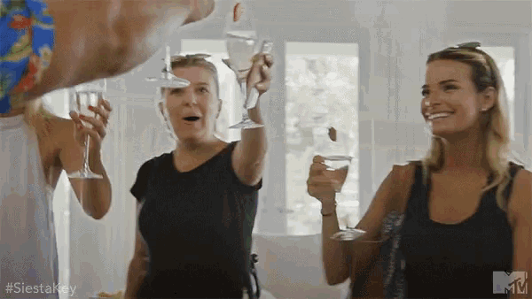 a group of women are toasting with wine glasses in a room with the hashtag #siestakey