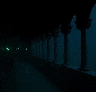 a row of columns in a dark room with green lights