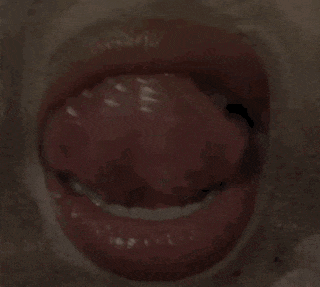 a close up of a person 's mouth with a gold grill on their tongue