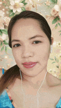 a woman wearing headphones stands in front of a floral backdrop