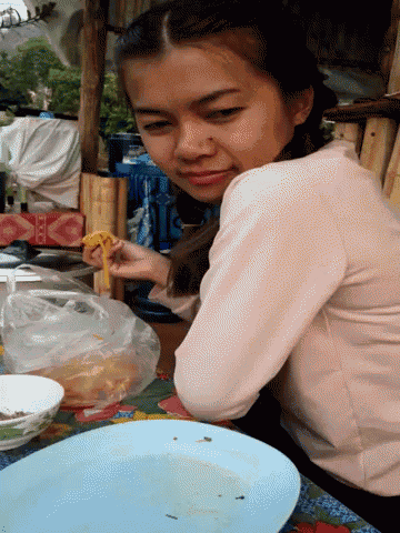 a woman is sitting at a table with a plate of food in front of her