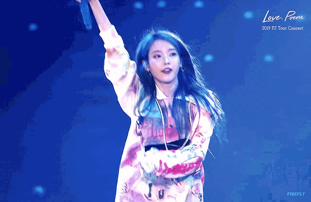 a woman holding a microphone in front of a blue background that says love poem on it
