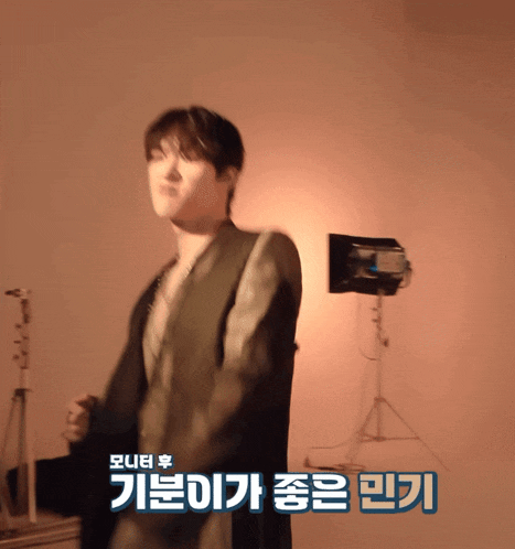 a blurry picture of a man with korean writing on the bottom right