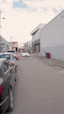 a row of cars are parked on a narrow street