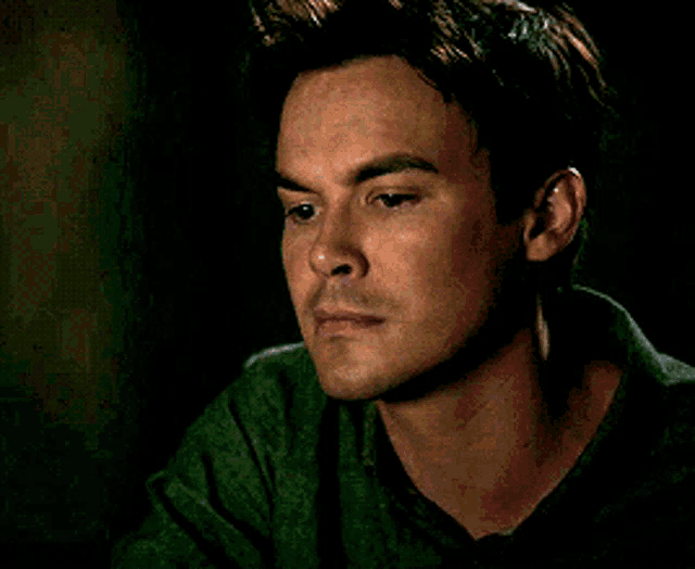 a close up of a man 's face in a dark room