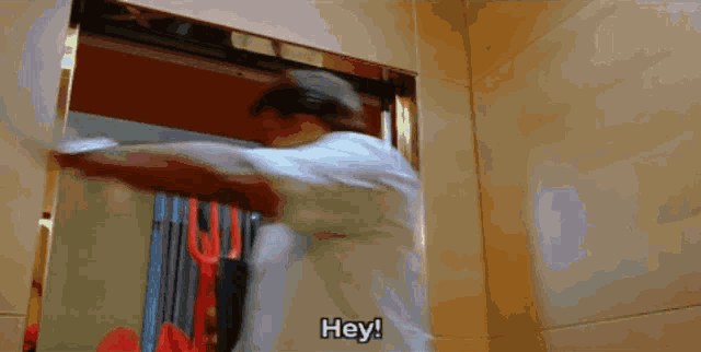 a man is getting out of an elevator and says " hey "