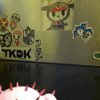 a sticker on a wall that says tkdk is surrounded by other stickers