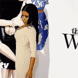 a woman in a white dress is standing in front of a sign that says " the w "