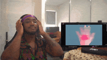 a man wearing headphones looks at a computer screen with the word joby on it