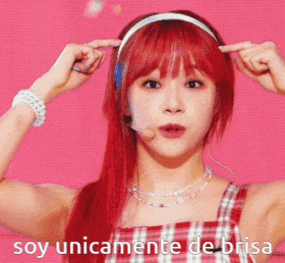 a woman with red hair is wearing headphones and a headband with the words soy unicamente de brisa on the bottom