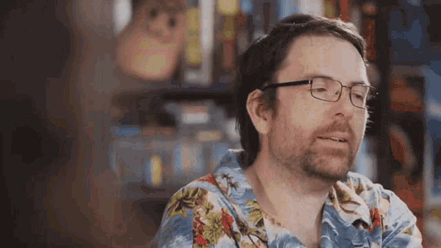 a man wearing glasses and a hawaiian shirt