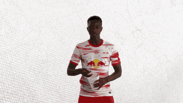 a soccer player wearing a red and white jersey with a bull on it
