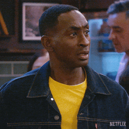 a man wearing a yellow shirt and a denim jacket has the word nope on his chest