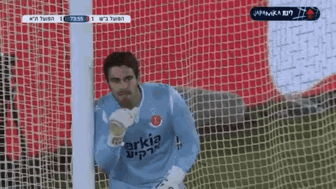 a soccer goalie wearing a blue shirt that says arkia